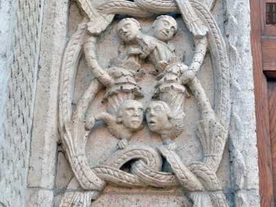 ... al lato opposto una figura maschile li raccoglie in un contenitore sul capo. Volti di nobili e religiosi si intrecciano tra le spire di un drago...
